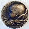 A bronze medal created by Marie Uchytilova with a motif of a newborn baby and a broken rose bud as a sign of a wasted life. (5cm)
